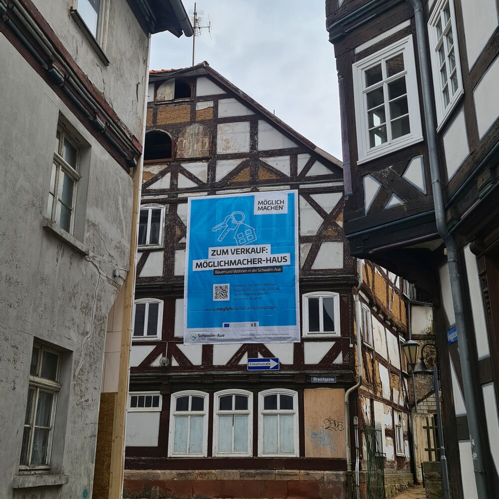 Ein großes Werbeplakat der Schwalm-Aue hängt an einem alten Fachwerkhaus zu der Kampagne Möglichmachen