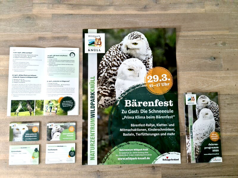 Broschüren und Karten vom Wildpark Knüll über die Ereignisse und Programm liegen auf einem Holztisch